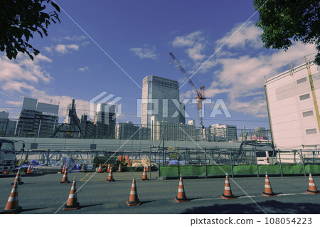 Road under construction and cranes and buildings visible in the background 108054223