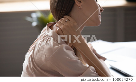 Close up view fatigued woman touches nape massaging tensed muscles Close up view fatigued woman touches nape massaging tensed muscles 108054270