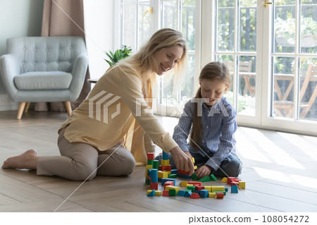 Happy mom and daughter kid playing on warm floor Happy mom and daughter kid playing on warm floor 108054272