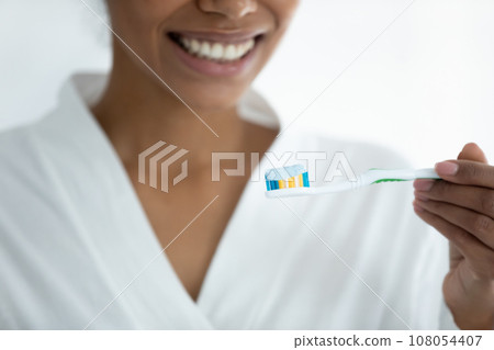 Close up of african American woman brush teeth in bath 108054407