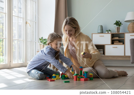 Cheerful excited mom and kid playing learning game at home Cheerful excited mom and kid playing learning game at home 108054421