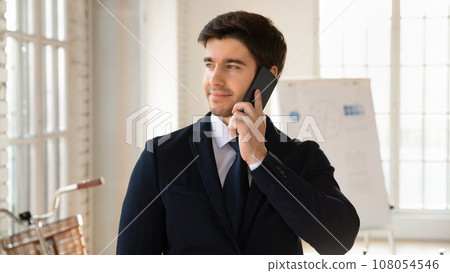 Happy pensive business owner man talking on cell 108054546