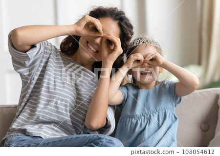 Portrait of happy mom and small daughter make funny faces 108054612