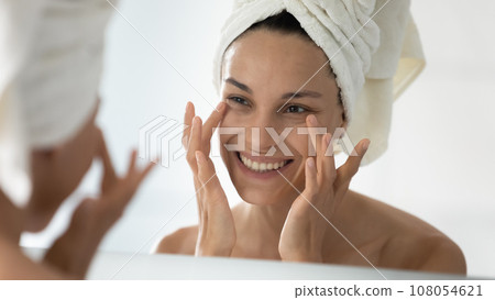 Smiling young woman do facial procedures in bathroom Smiling young woman do facial procedures in bathroom 108054621