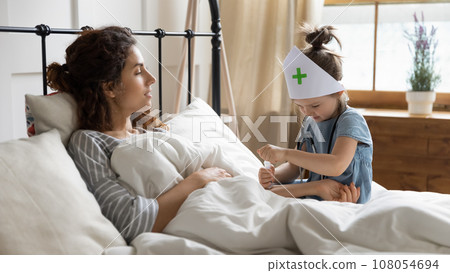Small girl playing doctor with young mom Small girl playing doctor with young mom 108054694