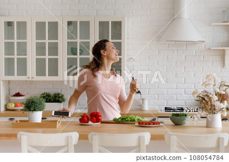 Happy chef girl having fun in kitchen, cooking healthy food Happy chef girl having fun in kitchen, cooking healthy food 108054784