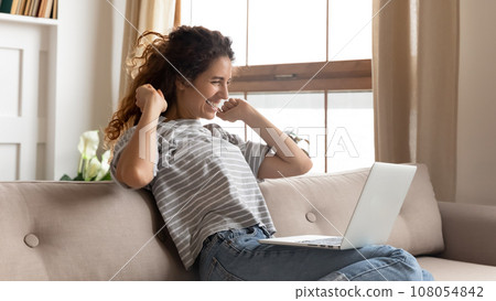 Excited young woman feel euphoric working on laptop 108054842
