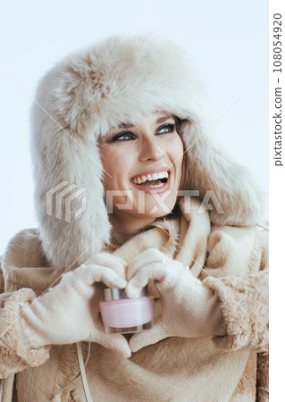 smiling stylish woman in winter coat and fur hat on white smiling stylish woman in winter coat and fur hat on white 108054920