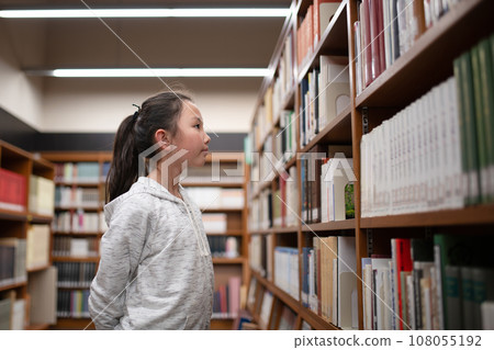 A girl choosing a book 108055192