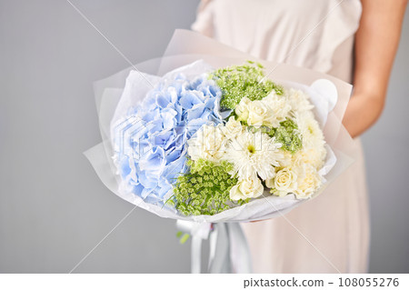 Small Beautiful bouquet of mixed flowers in woman hand. Floral shop concept . Beautiful fresh cut bouquet. Flowers delivery Small Beautiful bouquet of mixed flowers in woman hand. Floral shop concept . Beautiful fresh cut bouquet. Flowers delivery 108055276