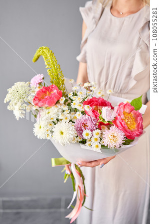 Beautiful bouquet with peonies flowers in woman hand. Floral shop concept . Beautiful fresh cut bouquet. Flowers delivery 108055281