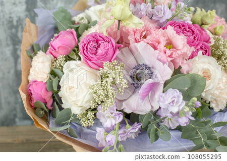 Small Beautiful bouquet of mixed flowers in woman hand. Floral shop concept . Beautiful fresh cut bouquet. Flowers delivery 108055295