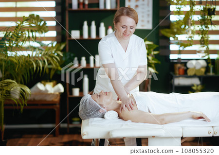 massage therapist in spa salon massaging clients shoulder 108055320