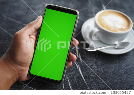 holding a cpu of coffee and using smart phone with green screen holding a cpu of coffee and using smart phone with green screen 108055457