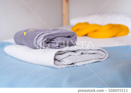 pile of gray and white color shower towel on bed pile of gray and white color shower towel on bed 108055511