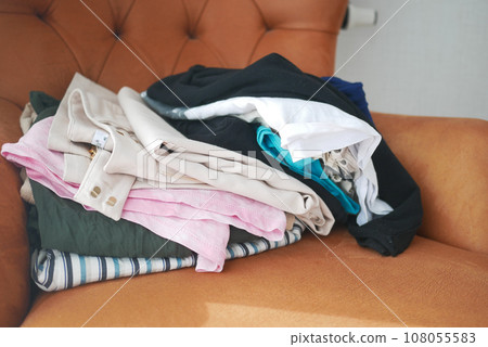 Messy clothes on sofa at home  108055583