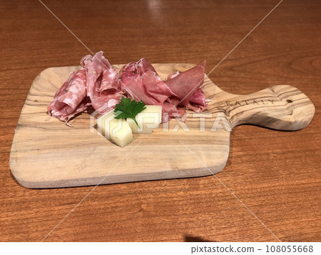 Raw ham and cheese on a stylish cutting board Raw ham and cheese on a stylish cutting board 108055668