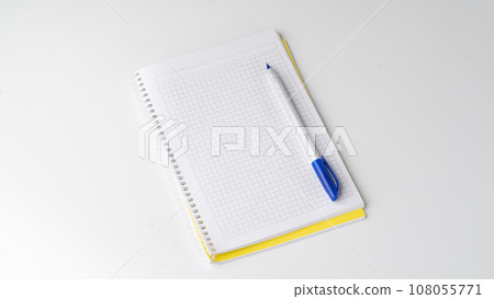 Checkered notebook with pen on white background, space for inscription Checkered notebook with pen on white background, space for inscription 108055771