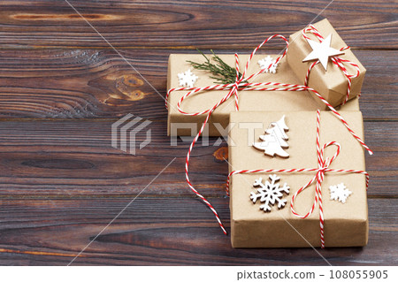 Three Festive Boxes in craf Paper Decorated with Snowflakes and star on Wooden Table. Top View 108055905