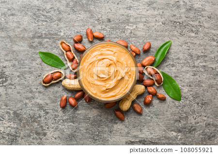 Bowl of peanut butter and peanuts on table background. top view with copy space. Creamy peanut pasta in small bowl 108055921