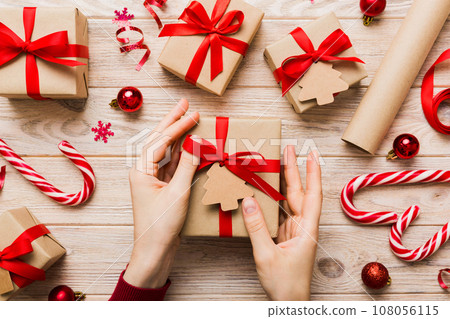 Woman hands holding gift box, preparing surprise for holiday, top view, Christmas and New Year concept 108056115