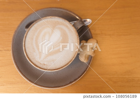 Coffee on a wooden table in a cafe, drawings on coffee. Coffee on a wooden table in a cafe, drawings on coffee. 108056189