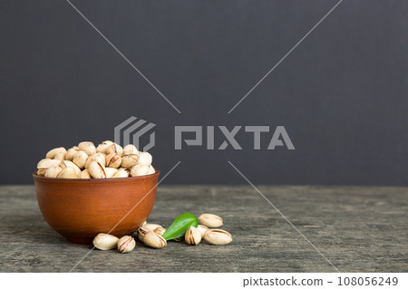 Fresh healthy Pistachios in bowl on colored table background. Top view Healthy eating concept. Super foods 108056249