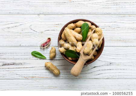 Fresh healthy peanuts in bowl on colored table background. Top view Healthy eating bertholletia concept. Super foods Fresh healthy peanuts in bowl on colored table background. Top view Healthy eating bertholletia concept. Super foods 108056255