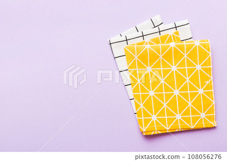 top view with yellow empty kitchen napkin isolated on table background. Folded cloth for mockup with copy space, Flat lay. Minimal style 108056276
