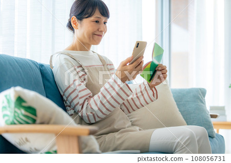 A housewife viewing a passbook 108056731