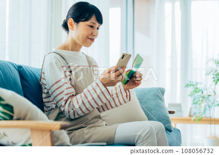 A housewife viewing a passbook 108056732