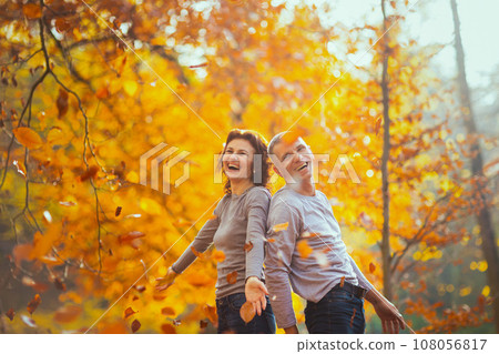 cheerful boyfriend and girlfriend in park throwing autumn leafs cheerful boyfriend and girlfriend in park throwing autumn leafs 108056817