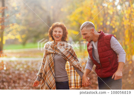 smiling stylish boyfriend and girlfriend in park walking 108056819