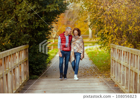 Full length portrait of smiling stylish couple in park walking Full length portrait of smiling stylish couple in park walking 108056823