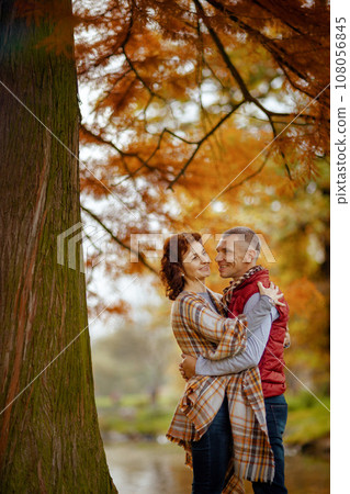 happy stylish couple in park embracing near tree 108056845