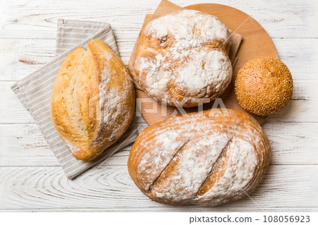 Assortment of freshly baked bread with napkin on rustic table top view. Healthy unleavened bread. French bread 108056923