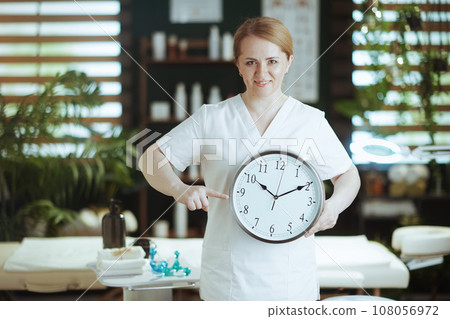 smiling female medical massage therapist in massage cabinet smiling female medical massage therapist in massage cabinet 108056972