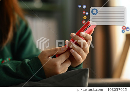 Young woman using mobile phone with likes, emoji icons while sharing or commenting in online community Young woman using mobile phone with likes, emoji icons while sharing or commenting in online community 108057025