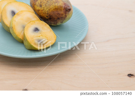 Pawpaw - fruit cut and placed on a plate Pawpaw - fruit cut and placed on a plate 108057140