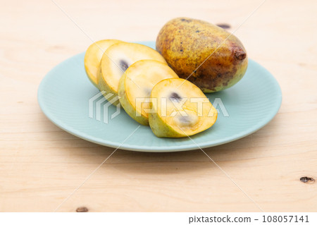 Pawpaw - fruit cut and placed on a plate Pawpaw - fruit cut and placed on a plate 108057141