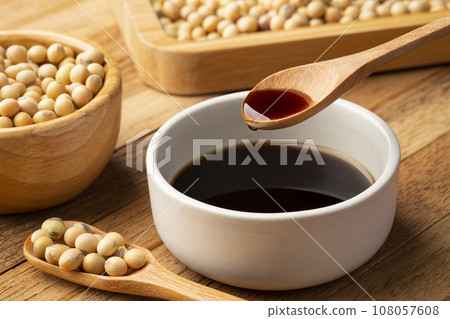 Soy sauce in wooden spoon and soy bean on wooden table Soy sauce in wooden spoon and soy bean on wooden table 108057608