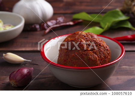 Thai red curry paste in white bowl,is a versatile and flavorful base for a variety of Thai dishes 108057610