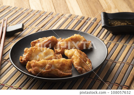 gyoza,Deep fried crispy dumplings in vegetable oil on black plate gyoza,Deep fried crispy dumplings in vegetable oil on black plate 108057632