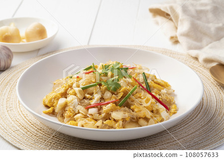Stir fried vemicelli with pickled garlic and egg in white plate 108057633