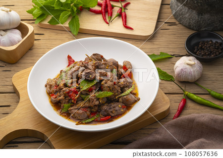 Stir-fried Chicken Giblets(livers, heart and gizzards) with Chillies and basil in white plate 108057636