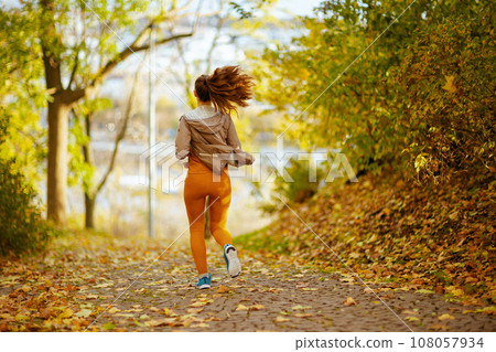 woman in fitness clothes in park running 108057934