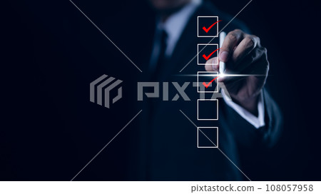 Businessman checking mark on checklist with a red checkmark. online checklist survey, filling out digital form checklist. take an assessment, questionnaire, evaluation, online survey, online exam, 108057958