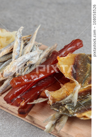 Fish snacks on a wooden board close-up. 108058526