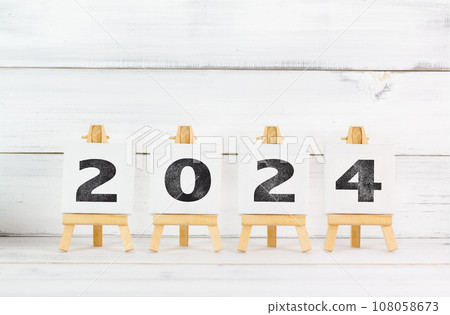 Upcoming 2024 New Year with Art Board over white wood background. Upcoming 2024 New Year with Art Board over white wood background. 108058673