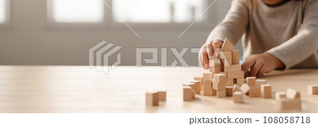 Kid playing with colorful wooden toy blocks. Little boy or girl building tower of block toys. Educational and creative toys and games for young children. Baby in white bedroom with rainbow bricks Kid playing with colorful wooden toy blocks. Little boy or girl building tower of block toys. Educational and creative toys and games for young children. Baby in white bedroom with rainbow bricks 108058718